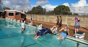 Image of people jumping into a pool.
