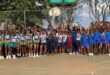 Image of young athletes in a group with their hands in the air.