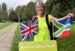 Image of woman holding a British and South African flag at parkrun Milano Nord.