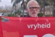Image of an elderly man holding a Vryheid parkrun banner.
