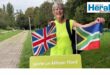 Image of woman holding a British and South African flag at parkrun Milano Nord.