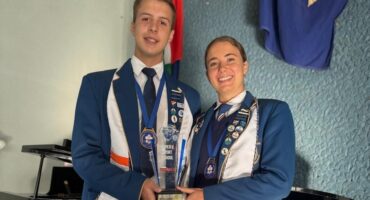 Image of head girl and head boy of Hoërskool Pionier holding a trophy.