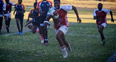 Image of a rugby player with ball in hand on his way to the try line.