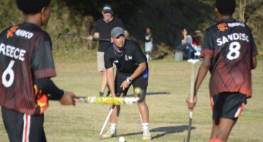 Image of hockey players in action with one player with the ball.