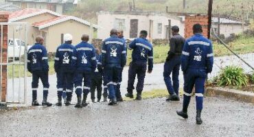 Image of fire figthers with their backs facing the camera walking away.