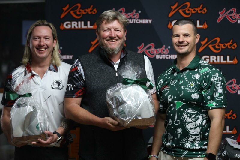 A photo of the winners of a gold day taken infront of a roots butchery banner.