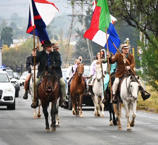 Several people photographed wearing historical attire and riding on horses holding flags representing the women and children lost during the Anglo-Boer-War.
