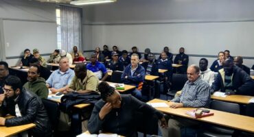 Photo of local business people in the Endumeni area meeting with SAPS officials in a lecture hall.