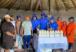 Image of Nontsikelelo Mhlongo, owner of Mhlongo Omhle, standing with Umzinyathi officials behind her dairy products.