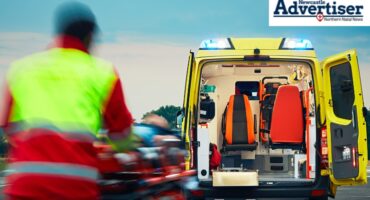 A illustrated image of a paramedic in action in front of an ambulance fleet. The NEwcastle Advertiser logo is in the top corner.