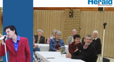 Image of elderly people watching as Andrew Mills sings.