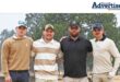 A group photo of several golf players posing on the greens in Newcastle.