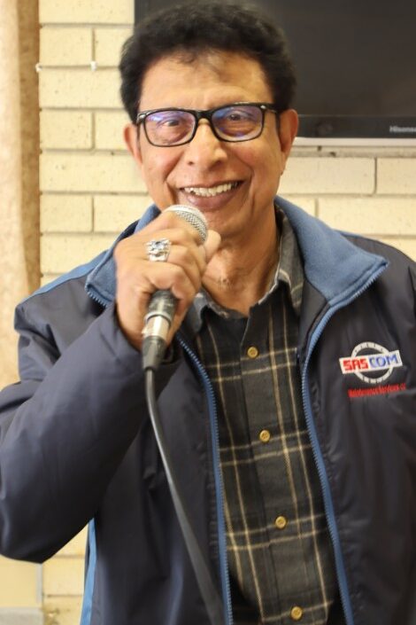 A man is photographed singing over a mic.