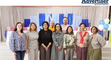 A photo of a group of people posing inside a hall.