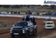 A photo of a group of oval Track Racers driving around the oval track course.