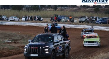 A photo of a group of oval Track Racers driving around the oval track course.