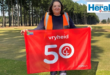 Image of woman holding a 50th parkrun event flag.