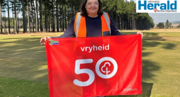 Image of woman holding a 50th parkrun event flag.