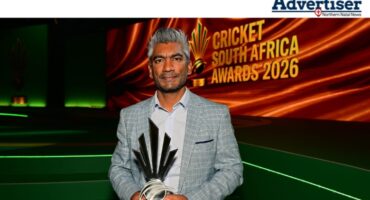 Newcast'es Rishi Nanan standing at a ceremony holding a trophy.