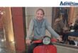 A photo of a young girl on ared scooter inside a restaurant.