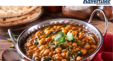 A photo of several bowls of various foods used in a curry dish.