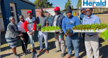 An image of Zakhele Xulu alongside various stakeholders who launched the One Home, One Garden initiative during Mandela Day; 67 minutes in Hlobane.