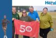 Image of parkrunners holding a 50th event banner.
