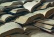 Image of open books stacked up.