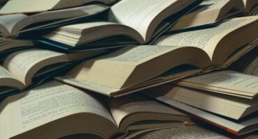 Image of open books stacked up.