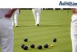 Bowlers pictured on abowling green with bowls on the field.