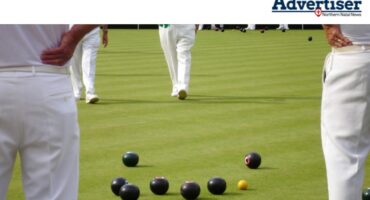 Bowlers pictured on abowling green with bowls on the field.