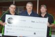 Image of three men holding a large cheque donation that went towards rural safety in the Dundee area.