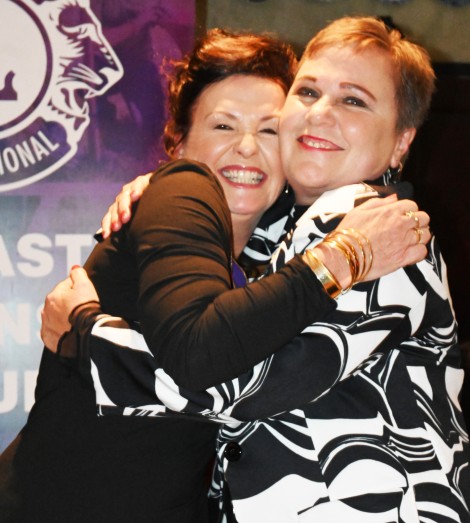 Two Lions Club Memmbers give eachother a big hug.