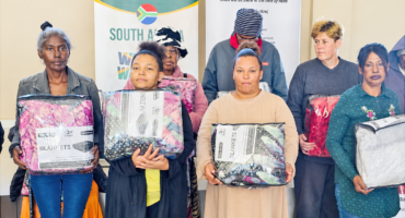 Image of people in Dannhauser receiving a donation of winter blankets.