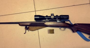 Image of a hunting rifle with scope and ammunition.