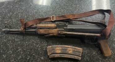 Image of a confiscated AK47 rifle and a magazine.
