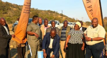 Image of people launching a water project but turning a sod.