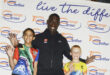Image of Vincent Aka, an Olympian and development officer for United World Wrestling with two young local wrestlers in Glencoe.
