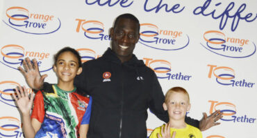 Image of Vincent Aka, an Olympian and development officer for United World Wrestling with two young local wrestlers in Glencoe.