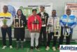 A photo of several anglers holding their trophies in front of a banner.