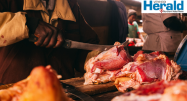 Image of a hand with a knife cutting meat.