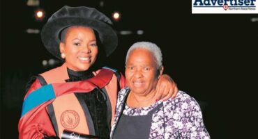 A photo taken of two women. One is an elderly woman and the other is a younger graduate.
