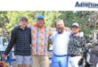 A group of golfers posed for a photo in front of a golf cart.