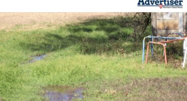 A photo of a play park submerged in water. Also seen in the photo is park equipment and a precast wall.