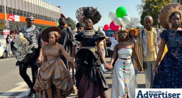 A photograph of a group of people dressed in high fashion, parading through Newcastle CBD.