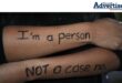 A photo of a young girl''s folder arms with "I'm a person not a case no" written on them.