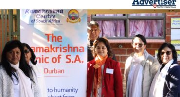 Dr Shivani Singh with members of the Ramakrishna Centre pose infront of a banner.