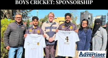 A photo of a group of people holding up new T-Shirts sponsord to the NHS 1st team Cricket.
