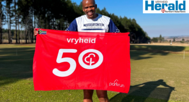 Image of runner holding 50th milestone parkrun flag.