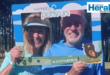 Image of male and female holding a Vryheid parkrun photo 'booth'.